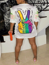 Rear view of a woman in a white t-shirt dress featuring a rainbow peace sign graphic and text.