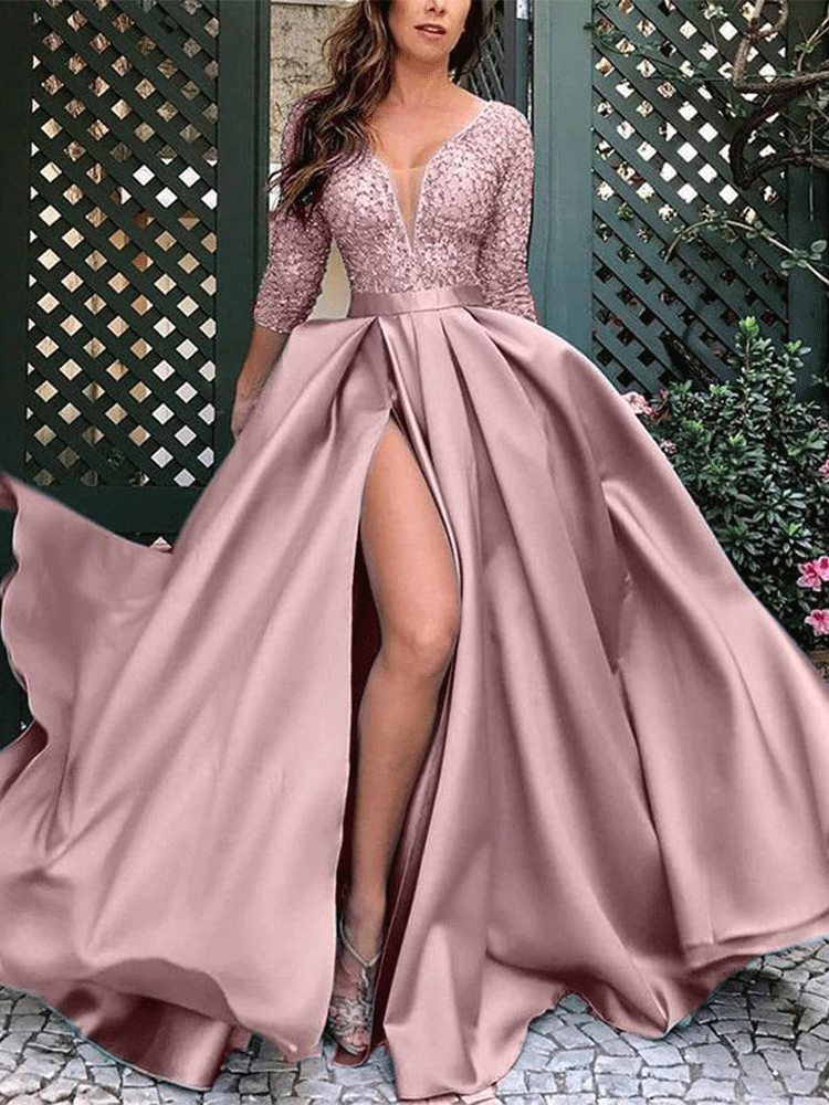 Woman in a flowing pink formal dress with a dramatic slit.