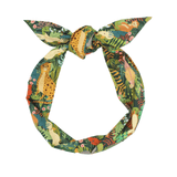 A green headband with a jungle animal and botanical print, tied in a knot at the top.