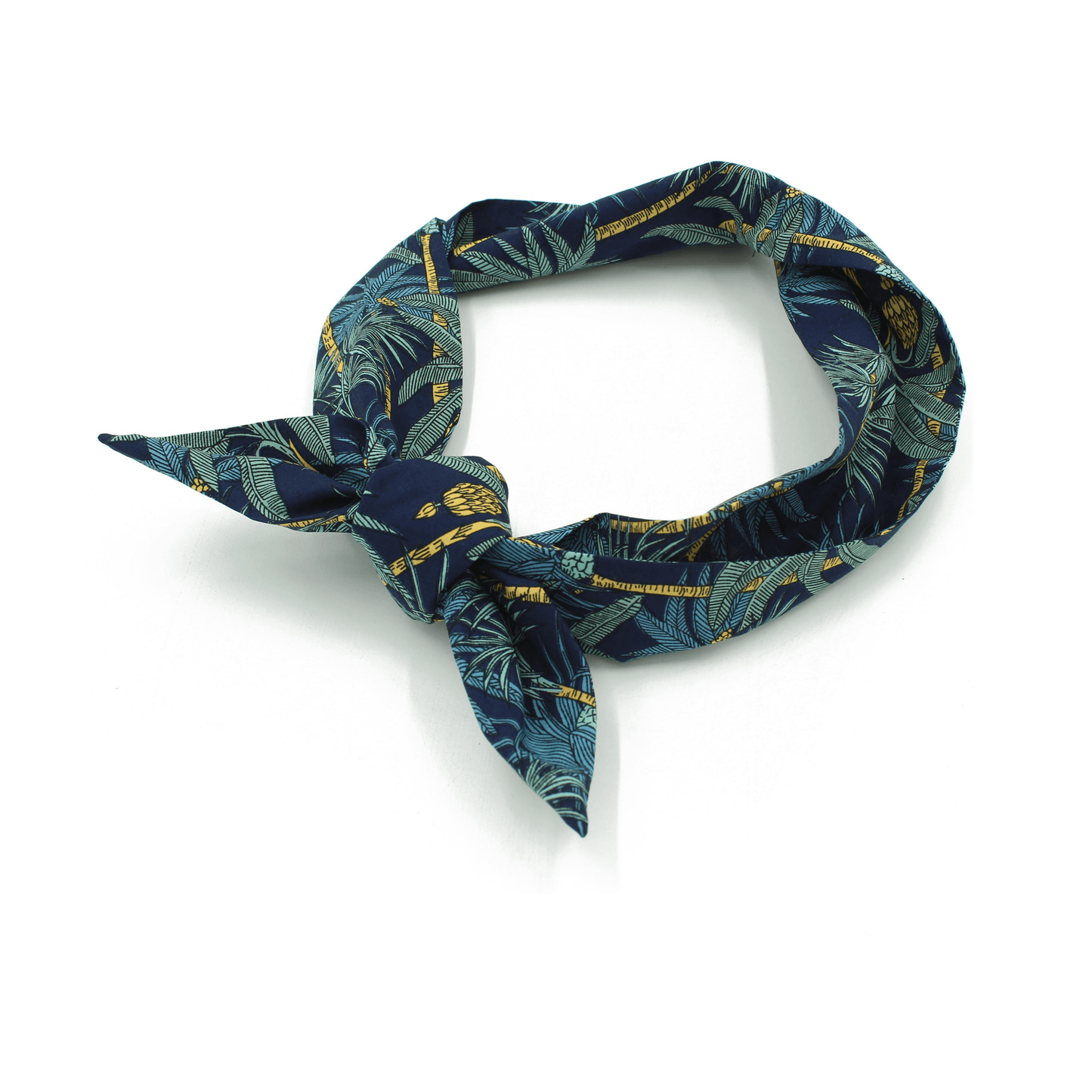A navy blue fabric headband with a tropical print, tied in a knot and laid flat with a shadow.
