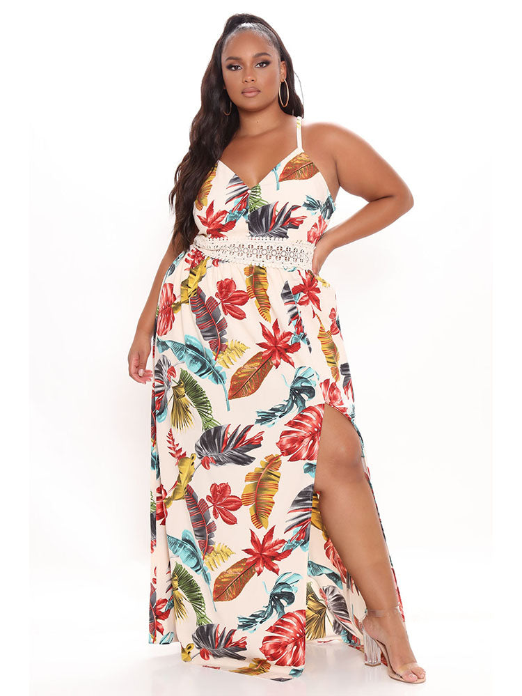 Plus-size woman wearing a cream-colored maxi dress with a tropical leaf print, V-neckline, crochet trim, and a side slit.