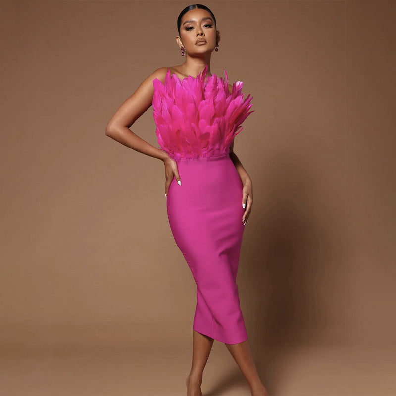 Model wearing a hot pink strapless bodycon dress with feather embellishment on the bust