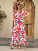 Woman wearing a floral print maxi dress, a straw hat, and sunglasses.