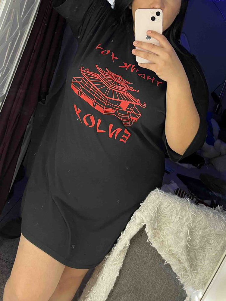 Woman taking a mirror selfie in a black t-shirt dress with red graphic print