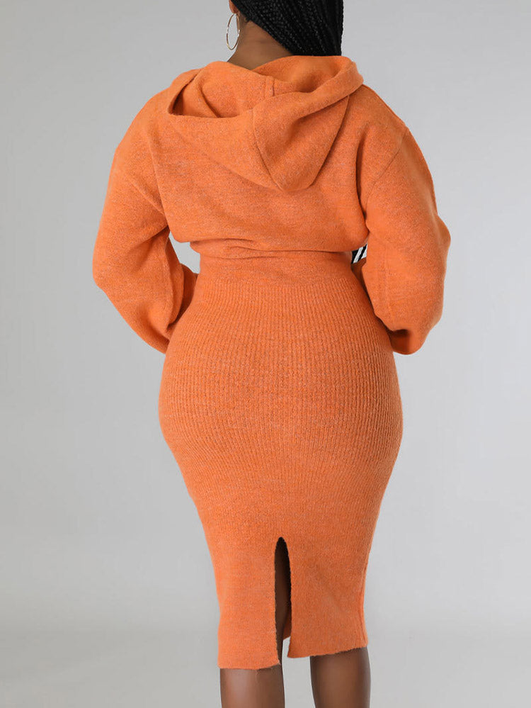 Woman wearing an orange hooded knit sweater and pencil skirt set, back view.