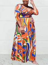 Side view of a woman in an orange and blue floral print wrap maxi dress.