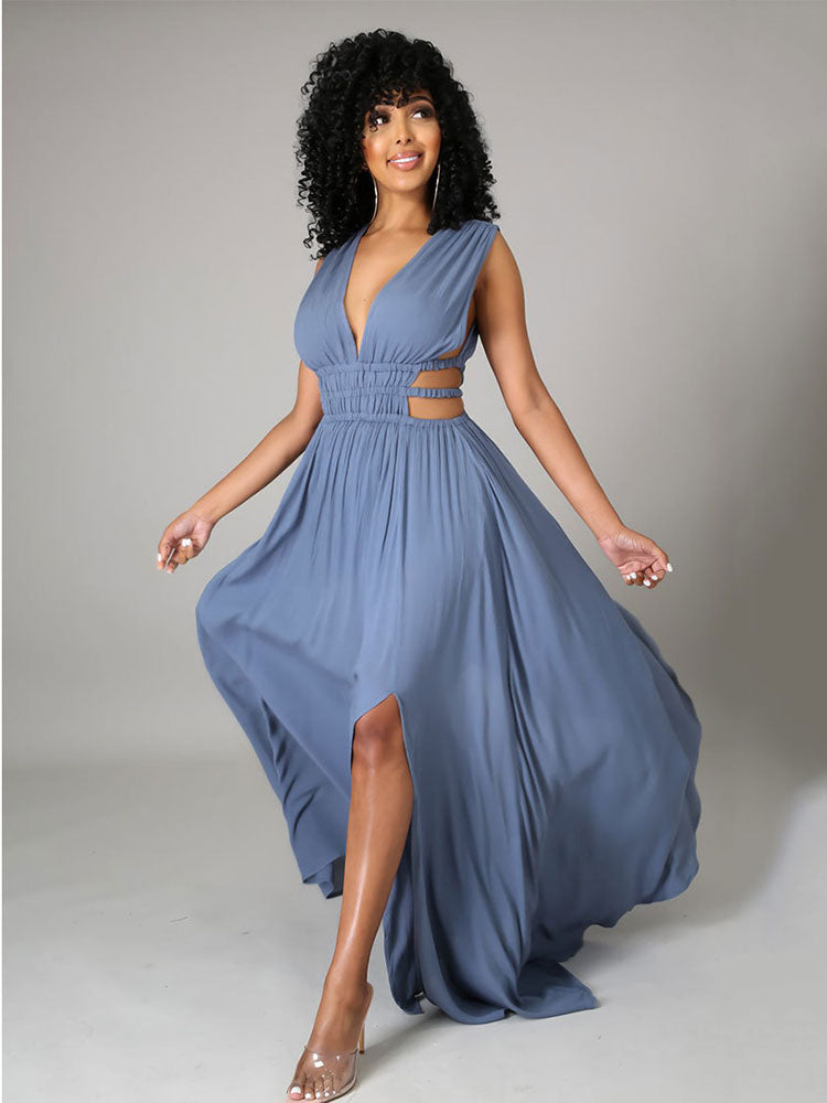 Woman in a blue sleeveless maxi dress with a plunging V-neck, cut-out waist details, and a high slit, posing dynamically.