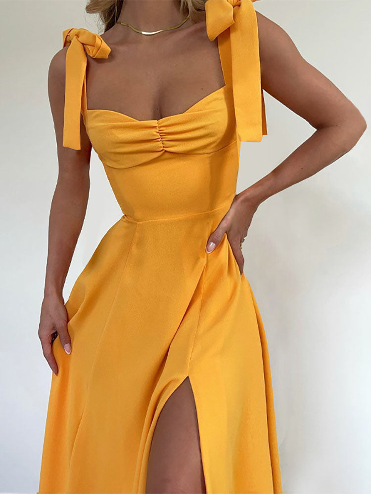 Close-up of a yellow dress with ruched bodice and tie shoulder straps