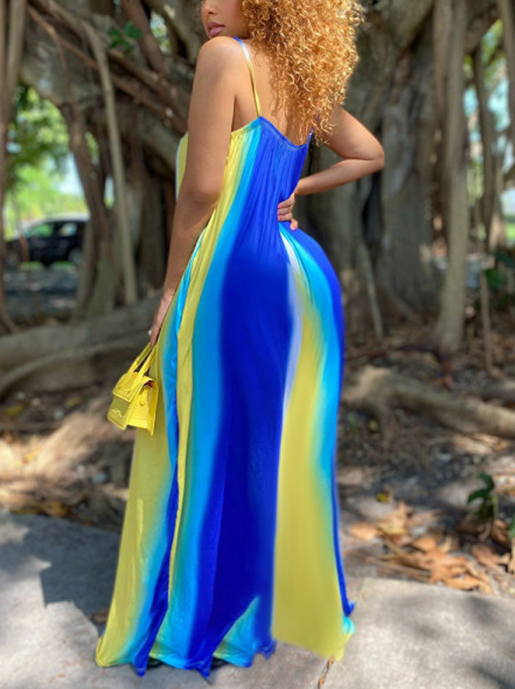 Side view of a woman wearing a blue, yellow, and white tie-dye maxi dress, highlighting the drape of the fabric.