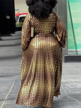Back view of a woman in a brown and gold polka dot maxi dress, showing the full length and fit.