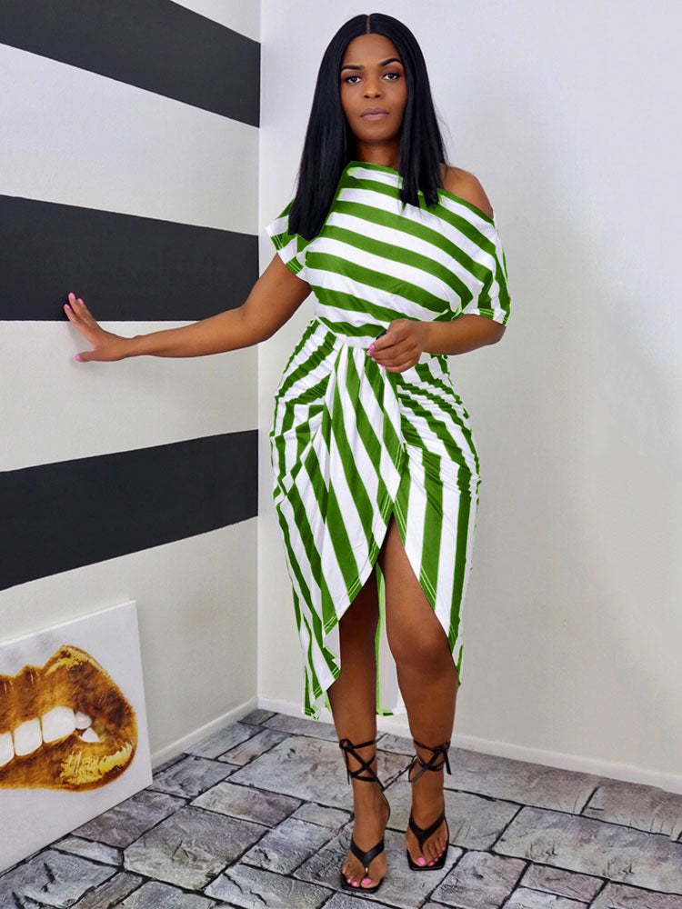 Woman wearing a green and white striped off-the-shoulder dress with an asymmetrical hemline