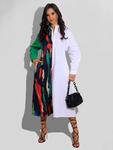 Woman wearing a long-sleeved, asymmetrical color block shirt dress with a white side and a printed side, holding a black handbag.