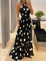 Woman wearing a black maxi dress with a white polka dot print