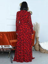 Back view of a woman in a red leopard print maxi dress with long sleeves and a belted waist.