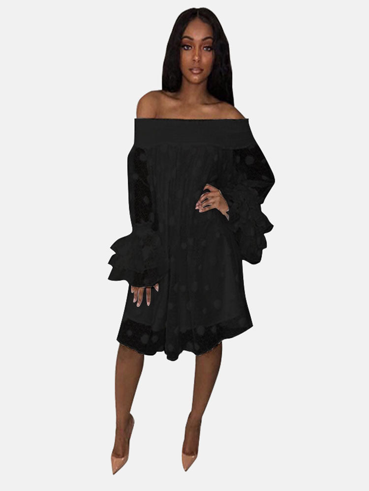 Woman wearing a black off-the-shoulder polka dot dress with ruffled bell sleeves and nude heels