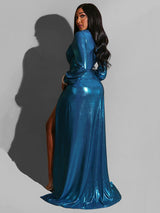 Rear view of a woman in a long, metallic blue formal dress, highlighting the back and train of the gown.