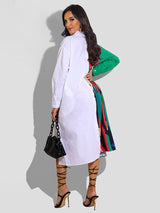 Back view of a woman wearing a long-sleeved, asymmetrical color block shirt dress with a white side and a printed side.