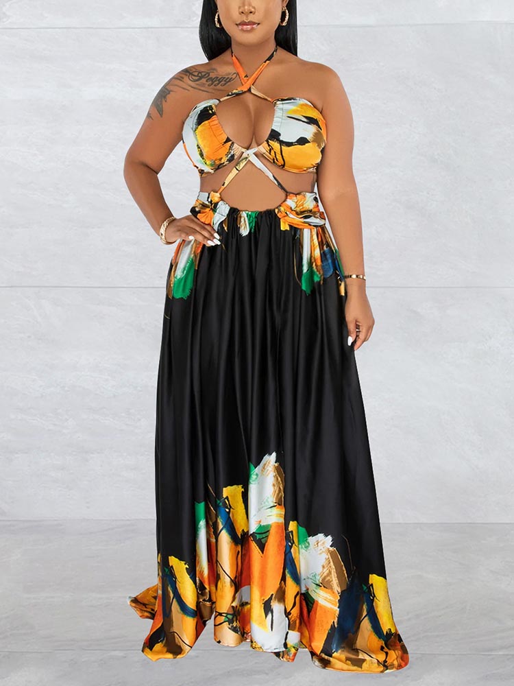 woman wearing a black abstract print halter neck maxi dress with cut-out details and a side slit