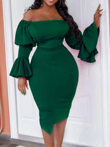 Woman in a dark green off-the-shoulder dress with ruffled sleeves, standing outdoors.