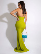 Woman in a lime green halter maxi dress with cut-outs and a ring accent, back view