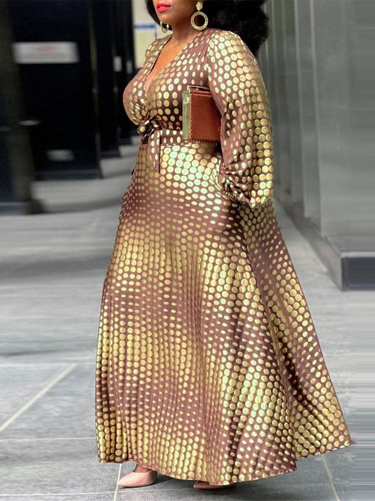 Side view of a woman in a brown and gold polka dot maxi dress, highlighting the A-line silhouette.
