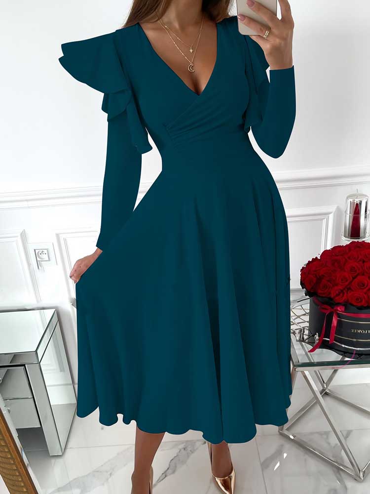 woman wearing a teal V-neck dress with ruffled long sleeves and a flared skirt