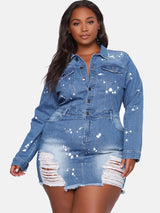 Plus-size model wearing a distressed denim mini dress with white paint splatter details and a collared neckline.