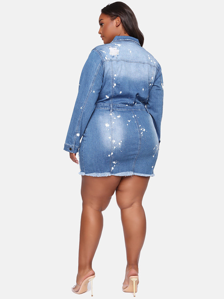 Back view of a plus-size model in a distressed denim mini dress with paint splatter, showing the details from the rear.