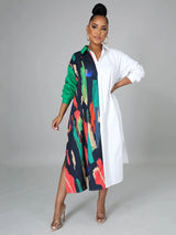 Woman wearing a long-sleeved, asymmetrical color block shirt dress with a white side and a printed side, posing against a grey background.