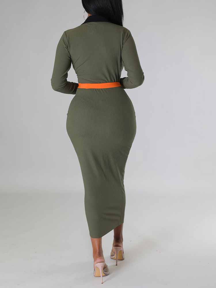 Back view of a woman in a long-sleeved olive green ribbed midi dress with contrasting orange panels.