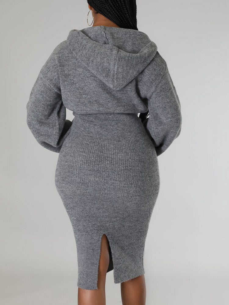 Woman wearing a grey hooded knit sweater and pencil skirt set, back view.
