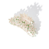 white floral claw clip with gemstones and shadow