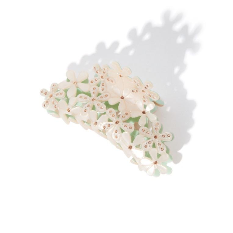 white floral claw clip with gemstones and shadow