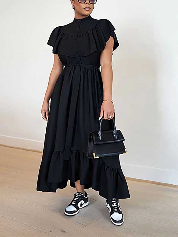 Full-length view of a woman in a black ruffled midi dress.