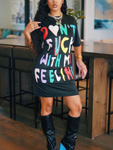 Woman wearing a black t-shirt dress with a colorful graphic print that reads "Don't F*** With My Feelings".