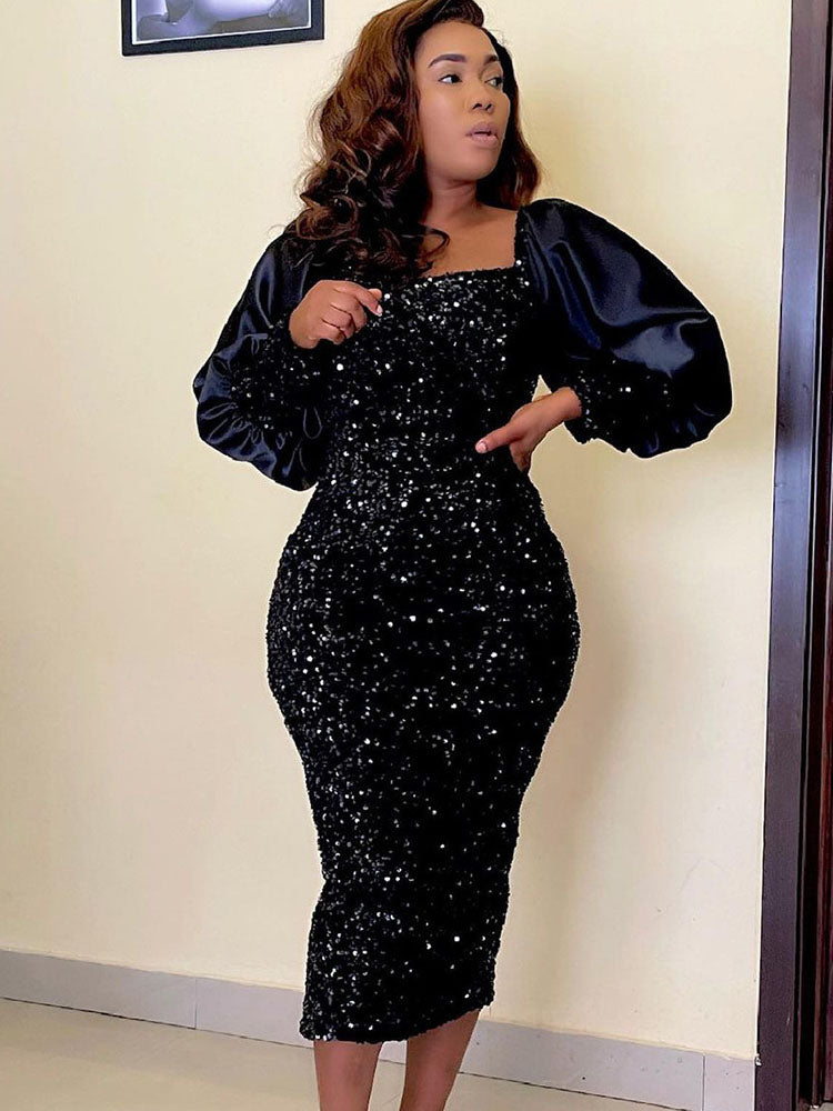 Woman in a black sequined midi dress with long puff sleeves and a square neckline, posing with her hand on her hip.