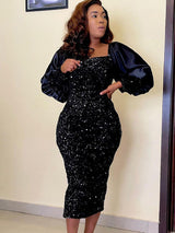 Woman in a black sequined midi dress with long puff sleeves and a square neckline, posing with her hand on her hip.