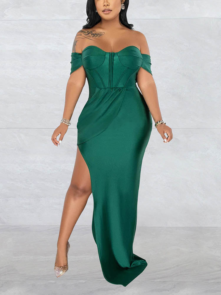 Woman wearing a floor-length emerald green off-the-shoulder dress with a high slit