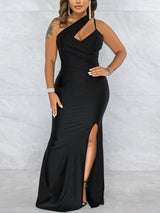 Woman wearing a floor-length black satin gown with an asymmetrical neckline and a high slit.