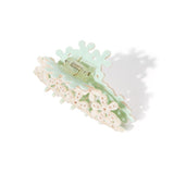 back view of white floral claw clip with gemstones