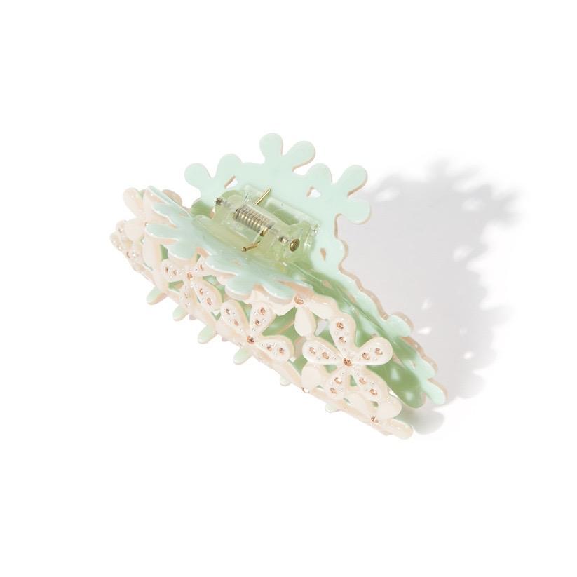 back view of white floral claw clip with gemstones