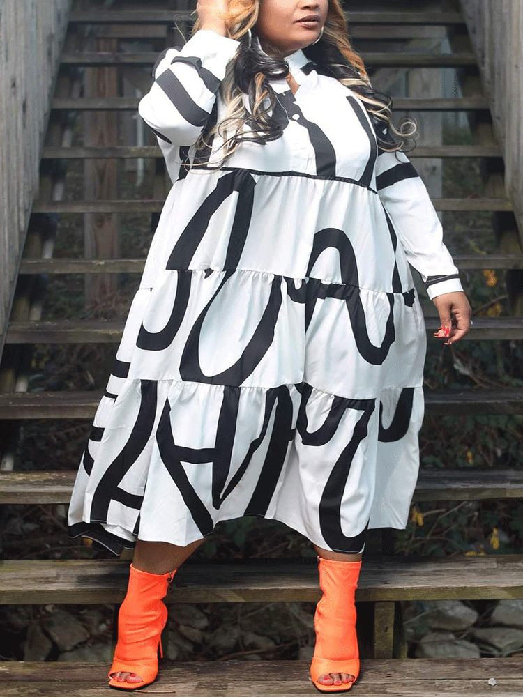 A woman wearing a white midi dress with a bold black graphic print and orange peep-toe boots, standing on wooden stairs.