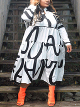 A woman wearing a white midi dress with a bold black graphic print and orange peep-toe boots, standing on wooden stairs.