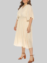 Plus-size woman wearing a cream midi dress with flutter sleeves and a smocked waist, shown from the side.
