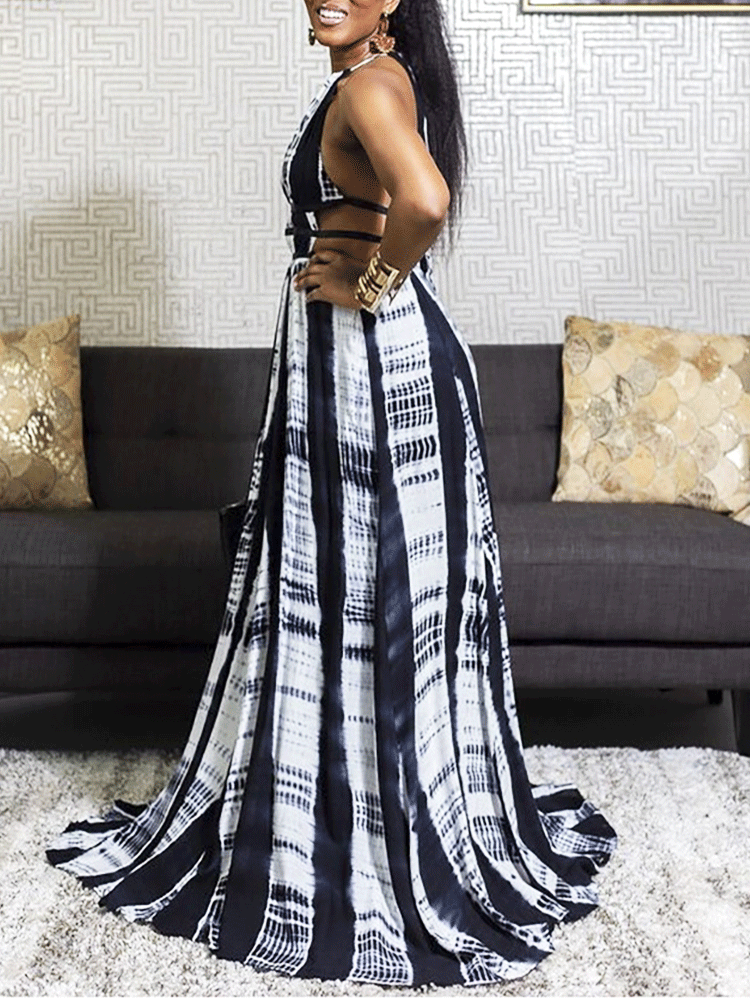 Side view of a woman in a black and white tie-dye maxi dress, showcasing the cutout details and flowy skirt.