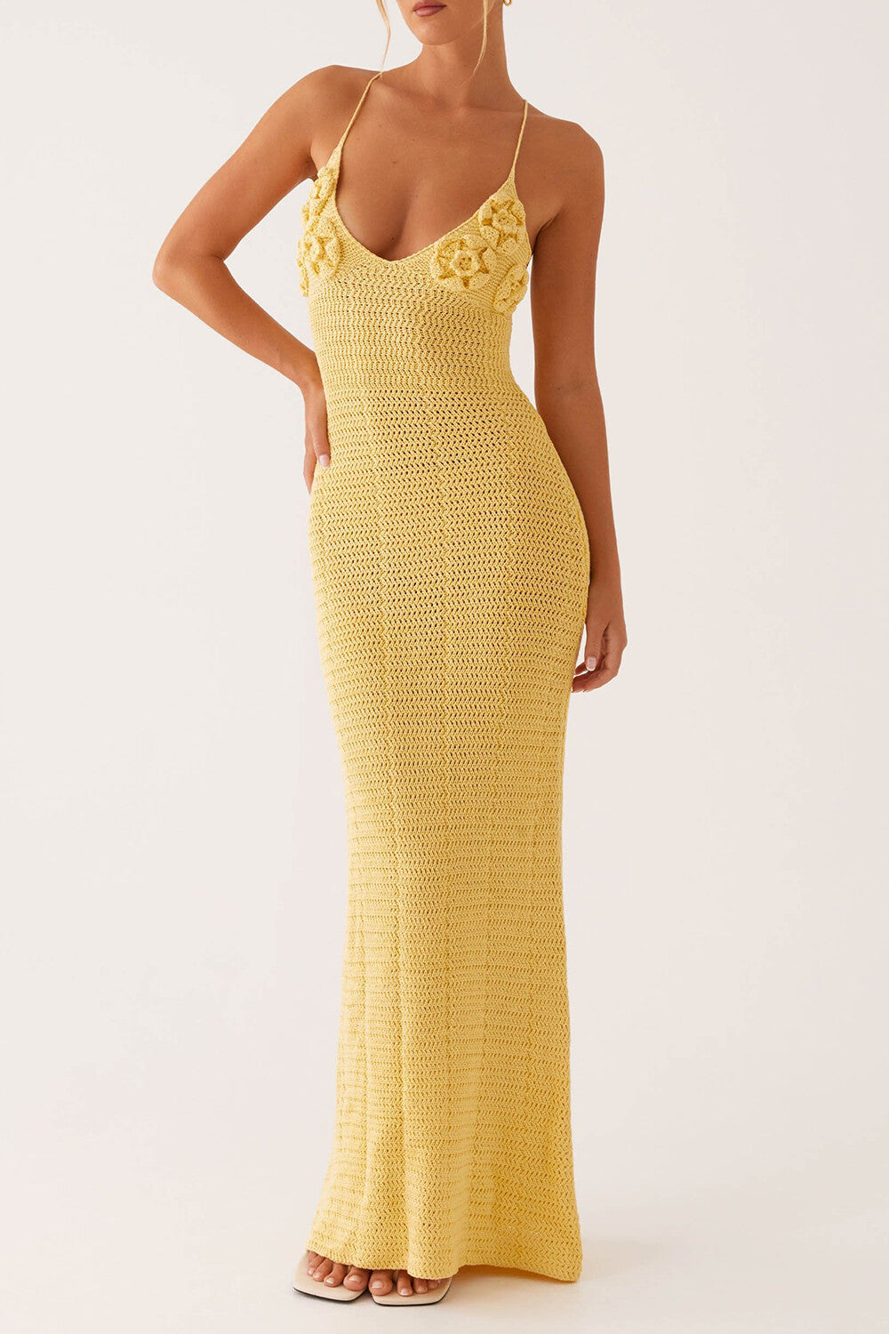 woman posing in a yellow crochet knit maxi dress with floral applique detail