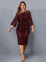 Woman wearing a burgundy sequined sheath dress with sheer geometric mesh bell sleeves