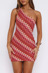 Model wearing a red and pink one-shoulder knit dress with a geometric pattern