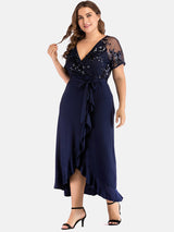 Plus-size black formal wrap dress with sequined top and sheer sleeves