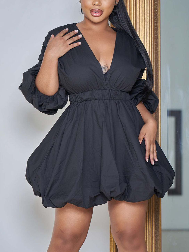 Woman wearing a black V-neck puffed sleeve mini dress with a bubble hem.